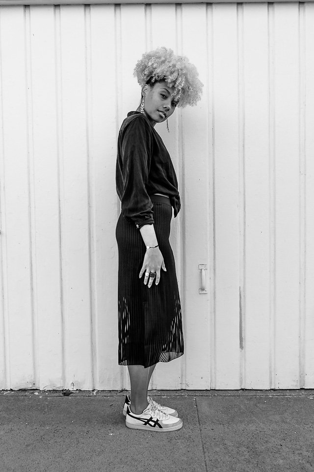 black and white photo of an athleisure outfit-thrift shirt-trendy skirt-livecgothesminded-fit femme