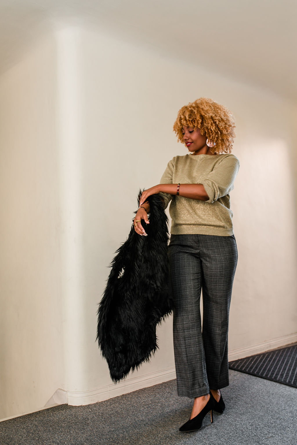 black women taking off fur vest wearing slacks and black high heels - reflect