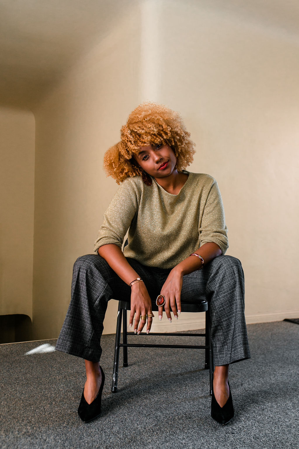 reflect -black woman with blonde curly hair wearing a work outfit