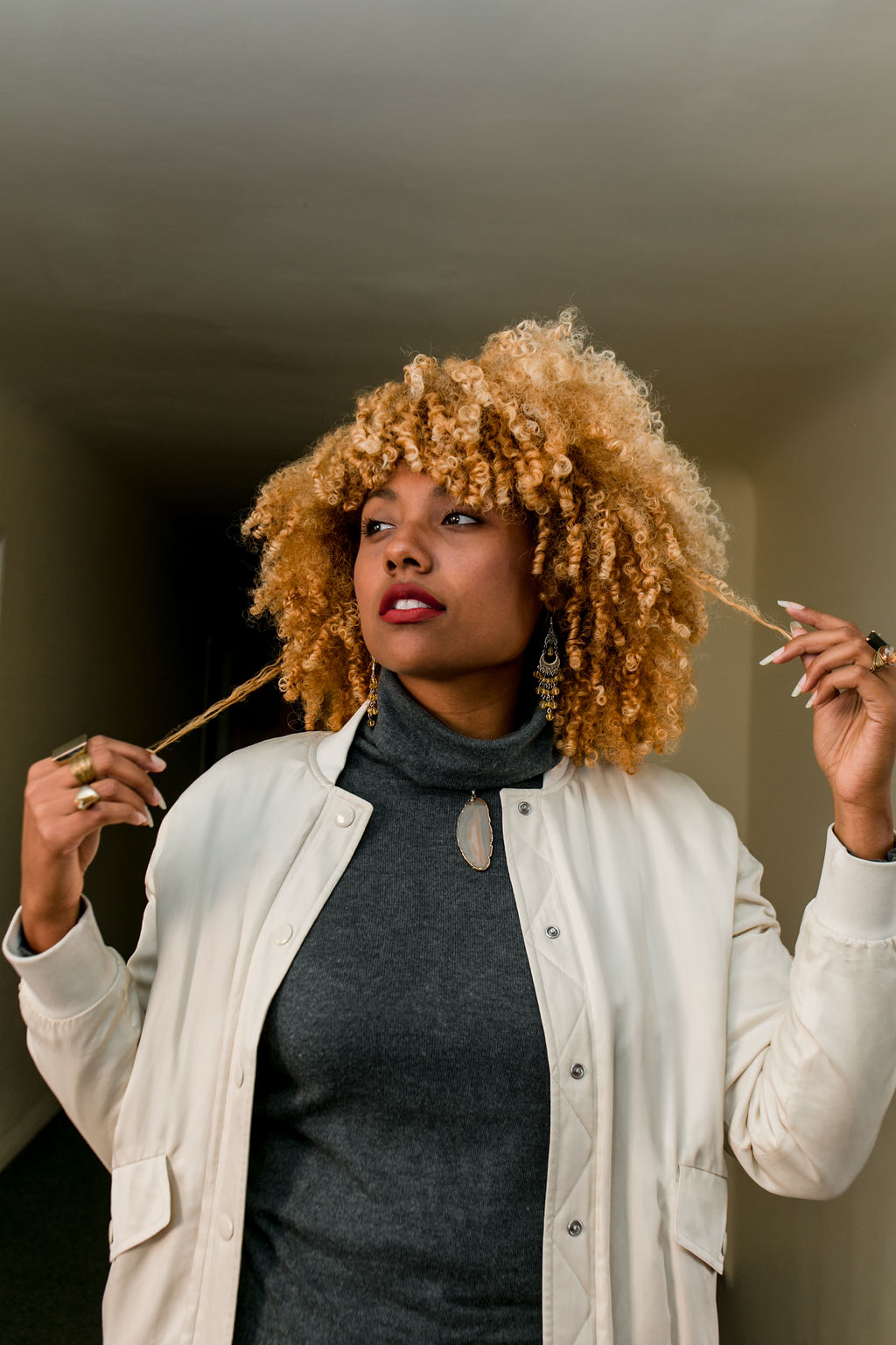 woman with blonde curly hair wearing slacks with sneakers