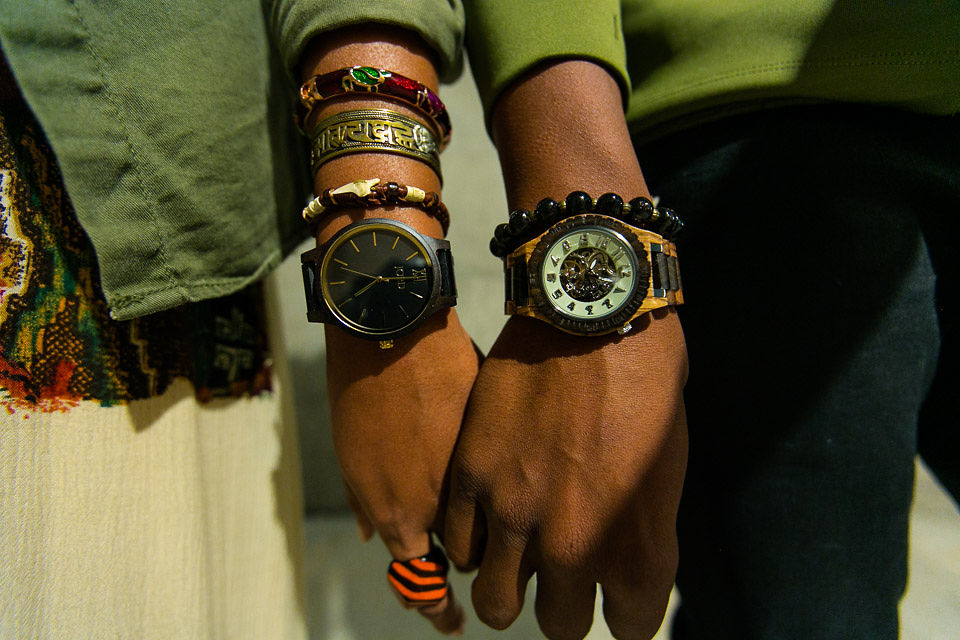 black couple holding hands wearing wood watches