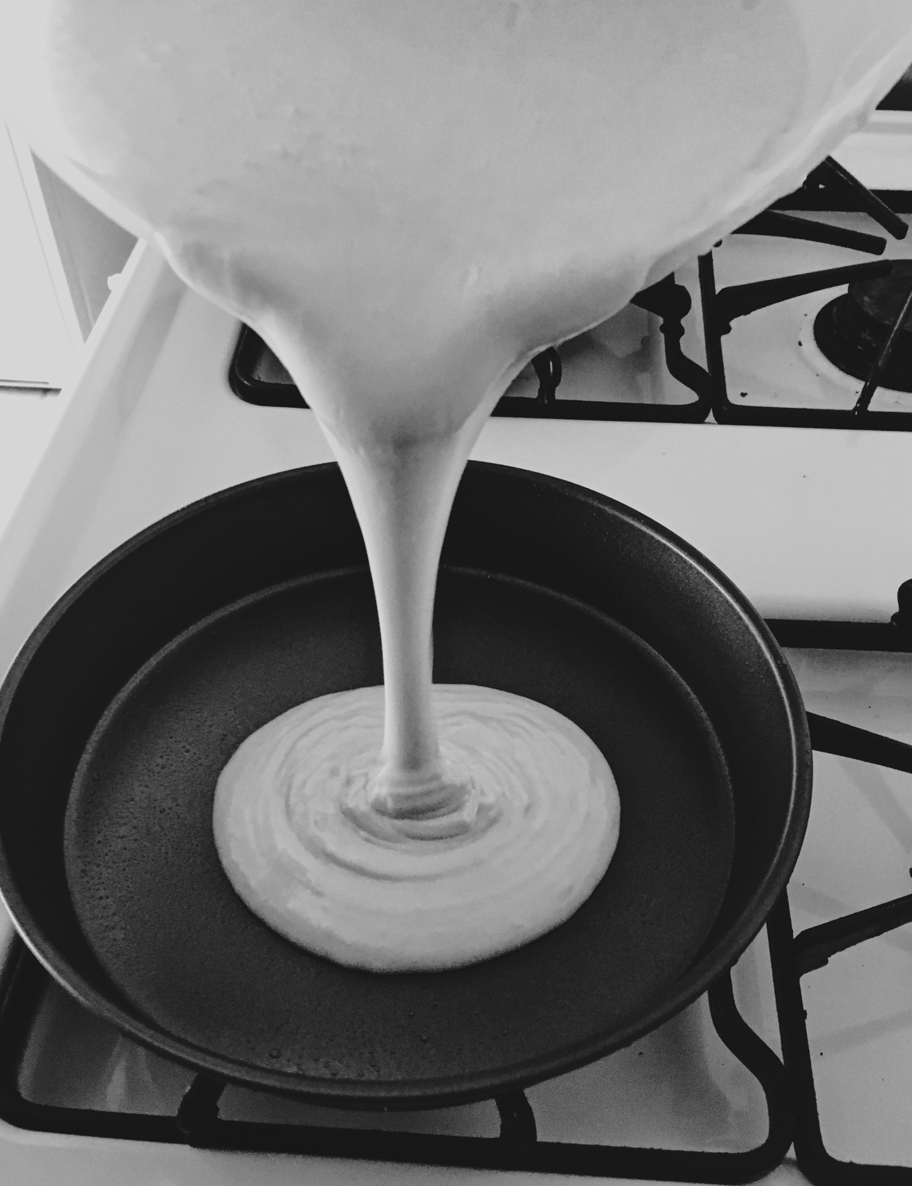 pouring cake batter into baking pans